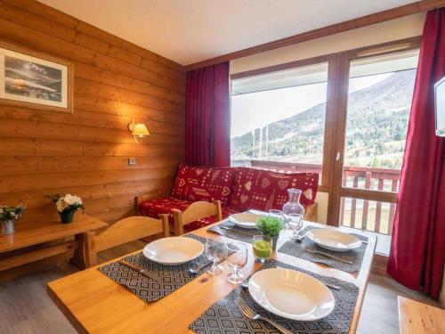 une salle à manger avec une table et un canapé dans l'établissement Bel appart 2 pièces avec balcon et casier à skis - FR-1-291-697, à Valmorel