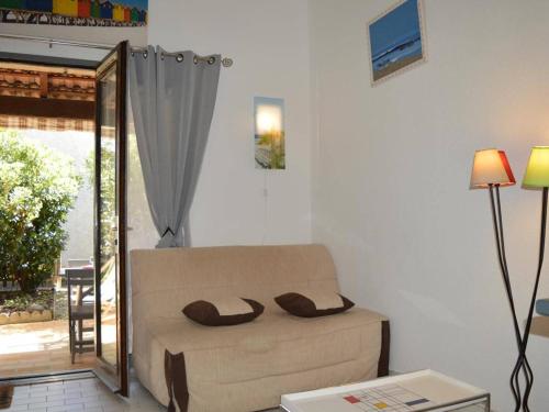 sala de estar con sofá y espejo en Maison Saint-Cyprien, 2 pièces, 6 personnes - FR-1-225D-323, en Saint Cyprien Plage