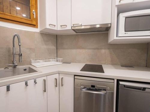 - une cuisine avec des placards blancs et un lave-vaisselle en acier inoxydable dans l'établissement Appartement Valmorel, 2 pièces, 5 personnes - FR-1-291-697, à Valmorel