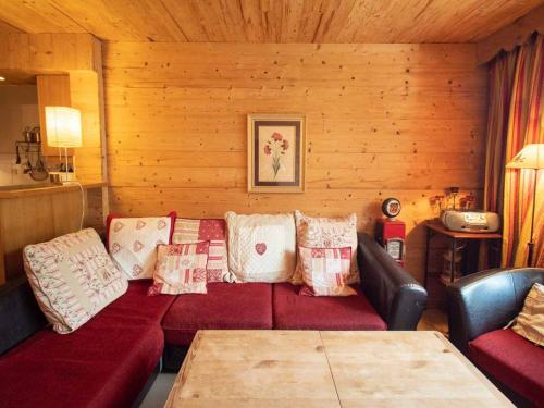 ヴァルモレルにあるAppartement Valmorel, 3 pièces, 6 personnes - FR-1-291-705の赤いソファと木製の壁が備わるリビングルーム