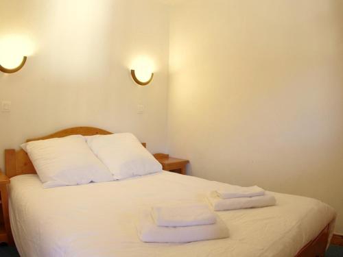 a bedroom with a white bed with two towels on it at Appartement Valmorel, 3 pièces, 7 personnes - FR-1-291-708 in Valmorel