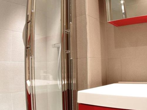 een douche met een glazen deur naast een wastafel bij Appartement Valmorel, 1 pièce, 4 personnes - FR-1-291-702 in Valmorel
