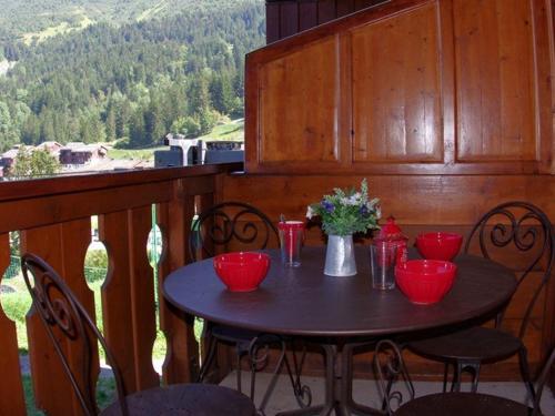 een zwarte tafel met rode kommen en bloemen op een balkon bij Appartement Valmorel, 1 pièce, 4 personnes - FR-1-291-702 in Valmorel