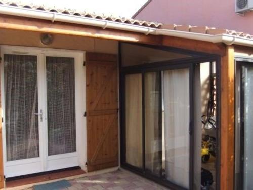 une porte d'entrée d'une maison avec des portes en verre dans l'établissement Charmante Villa T2 avec Terrasse, Clim en Option, Parking Privé, Proche Plage et Commerces - FR-1-81-279, au Barcarès