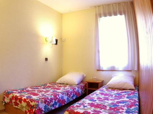 une petite chambre avec deux lits et une fenêtre dans l'établissement Studio divisible pour 4 pers avec terrasse, casier à skis à Valmorel - FR-1-291-757, à Valmorel