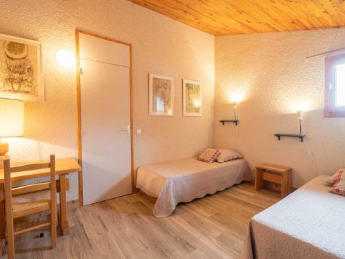 a room with two beds and a table and a desk at Appartement Valmorel, 3 pièces, 8 personnes - FR-1-291-766 in Valmorel