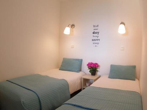 2 Betten in einem Zimmer mit Blumen an der Wand in der Unterkunft Appartement cosy 3 pièces - 7 pers, skis aux pieds, 2 salles de bain, parking disponible - FR-1-291-747 in Valmorel