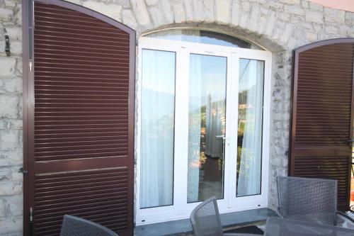 a patio door with a window and chairs at Balcone Fiorito in Menaggio