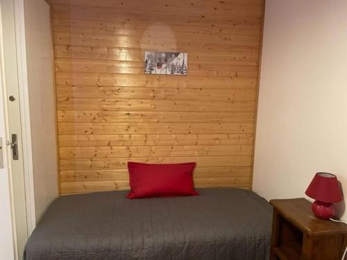 - une chambre avec un oreiller rouge sur un lit dans l'établissement Appartement 3 pièces, 7 pers. avec WIFI, à 20m des pistes, balcons et casier à skis - FR-1-262-77, à Forest des Baniols