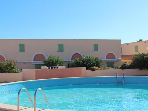 une grande piscine devant un immeuble dans l'établissement Maison Climatisée à 2 Pas de la Plage avec Piscine et Parking Privé, 6 Couchages - Gruissan - FR-1-229-486, à Gruissan
