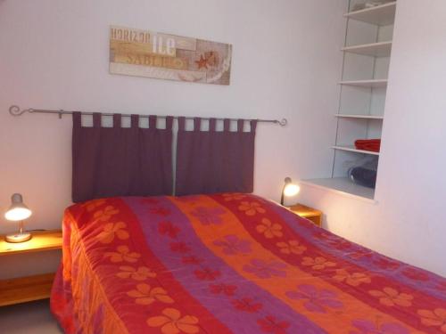 une chambre avec un lit avec une couverture rouge dans l'établissement Maison 4 pièces avec piscine, 300m plage, 6 couchages, Bretignolles-sur-Mer - FR-1-224A-26, à Bretignolles-sur-Mer