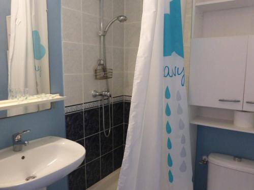 une salle de bain avec un lavabo et un rideau de douche dans l'établissement Maison 4 pièces avec piscine, 300m plage, 6 couchages, Bretignolles-sur-Mer - FR-1-224A-26, à Bretignolles-sur-Mer