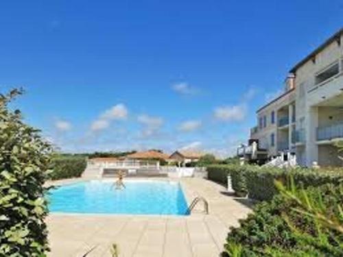 une piscine devant un immeuble dans l'établissement Maison 4 pièces avec piscine, 300m plage, 6 couchages, Bretignolles-sur-Mer - FR-1-224A-26, à Bretignolles-sur-Mer