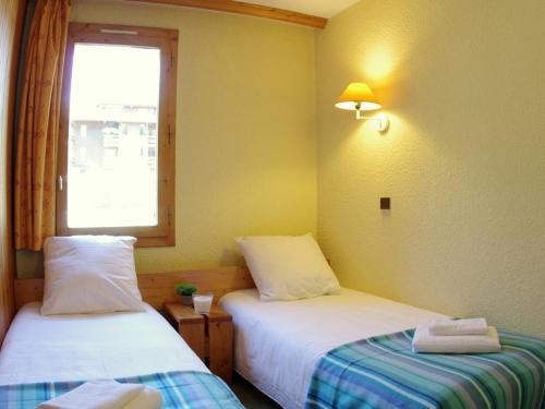 two beds in a room with a window at Appartement Valmorel, 1 pièce, 4 personnes - FR-1-291-783 in Valmorel