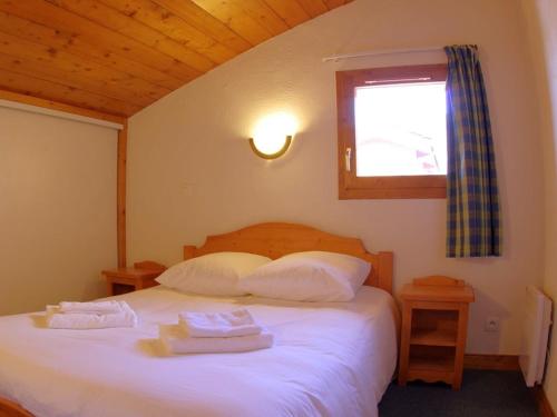 une chambre avec un lit avec deux serviettes dessus dans l'établissement Duplex 3P, 2 Chambres, Animaux OK, Casier à Skis, Valmorel - FR-1-291-728, à Valmorel