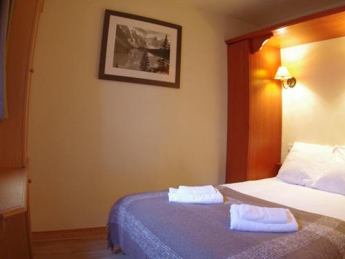 une chambre avec un lit avec deux serviettes dessus dans l'établissement Charmant 2 pièces avec balcon, animaux acceptés - FR-1-291-736, à Valmorel
