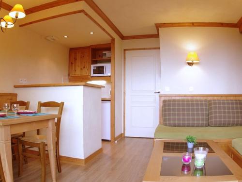 Il comprend une cuisine et un salon avec une table. dans l'établissement Charmant 2 pièces avec balcon, animaux acceptés - FR-1-291-736, à Valmorel