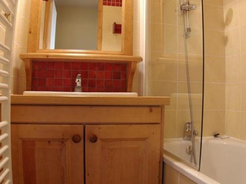 une salle de bain avec un lavabo, une baignoire et un miroir dans l'établissement Charmant 2 pièces avec balcon, animaux acceptés - FR-1-291-736, à Valmorel