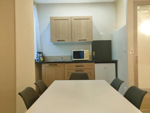 une cuisine avec une table et des chaises et un micro-ondes dans l'établissement Centré, 2 Pièces/5 Pers, Cauterets - Balcon, Près Thermes & Télécabine - FR-1-234-122, à Cauterets