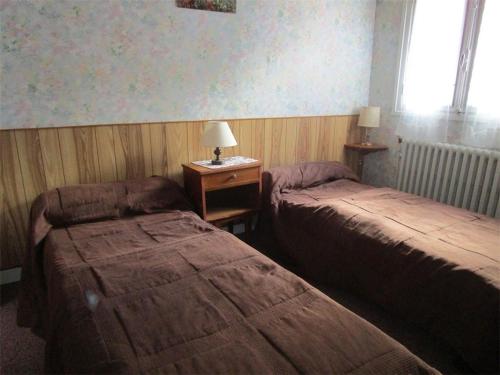 une chambre avec deux lits et une table avec une lampe dans l'établissement Appartement 2 pièces avec WIFI gratuit, proche thermes et télécabine, parking et casier à skis - FR-1-234-118, à Cauterets