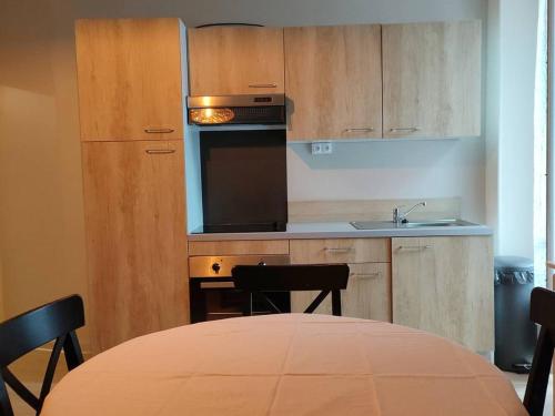 une cuisine avec une table et une cuisinière four supérieur dans l'établissement Appartement 3 pièces pour 6 personnes, centre-ville de Cauterets, proche thermes et télécabine - FR-1-234-124, à Cauterets
