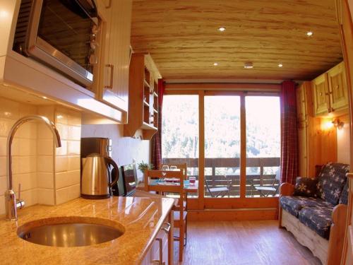 eine Küche mit Spüle und ein Wohnzimmer in der Unterkunft Studio cosy, animaux admis, parking disponible, Valmorel - FR-1-291-768 in Valmorel