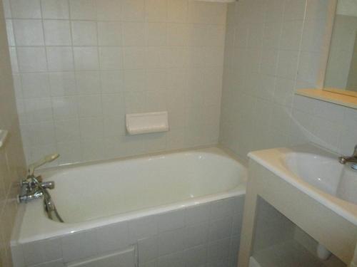 une salle de bain blanche avec une baignoire et un lavabo dans l'établissement Studio cosy 4 pers au cœur de Cauterets - FR-1-234-146, à Cauterets