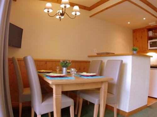 - une table à manger et des chaises dans la cuisine dans l'établissement Charmant T2 avec balcon à Valmorel - FR-1-291-773, à Valmorel