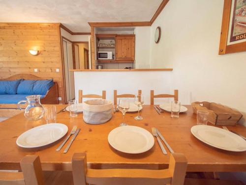 une table en bois avec des assiettes et des verres à vin dessus dans l'établissement Appartement 3 pièces avec balcon, animaux admis, parking. 7 couchages, Hameau de la Forêt - FR-1-291-776, à Valmorel