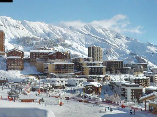 une ville dans la neige devant une montagne dans l'établissement Charmant 2 pièces cabine avec véranda, terrasse exposée sud, proche des pistes et commerces, WiFi inclus - FR-1-262-76, à Forest des Baniols