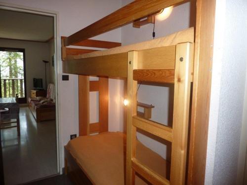 a wooden bunk bed in a room with a living room at Appartement Les Orres, 2 pièces, 8 personnes - FR-1-322-7 in Les Orres