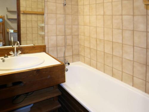 een badkamer met een wastafel, een bad en een spiegel bij Studio Les Orres, 1 pièce, 4 personnes - FR-1-322-21 in Les Orres