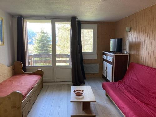 a living room with a red couch and a window at Appartement Orcières Merlette, 2 pièces, 8 personnes - FR-1-262-87 in Forest des Baniols