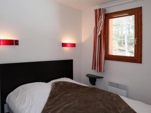 レ・ゾルにあるAppartement Les Orres, 2 pièces, 4 personnes - FR-1-322-32のベッドルーム1室(ベッド1台付)、赤い照明付きの窓が備わります。