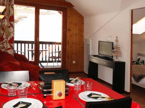 un salon avec une table et un tissu de table rouge dans l'établissement Appartement de standing avec piscine, sauna, hamman et wifi aux Orres 1800 - FR-1-322-44, aux Orres