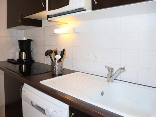 une cuisine avec un évier et un plan de travail dans l'établissement Appartement de standing avec piscine, sauna, hamman et wifi aux Orres 1800 - FR-1-322-44, aux Orres