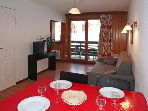 - un salon avec une table rouge et des verres à vin dans l'établissement Bel appartement avec piscine, sauna et hammam, 1 chambre, parking, animaux admis, wifi - FR-1-322-46, aux Orres