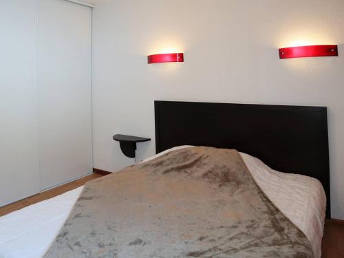 - une chambre avec un lit et deux lumières sur le mur dans l'établissement Bel appartement avec piscine, sauna et hammam, 1 chambre, parking, animaux admis, wifi - FR-1-322-46, aux Orres