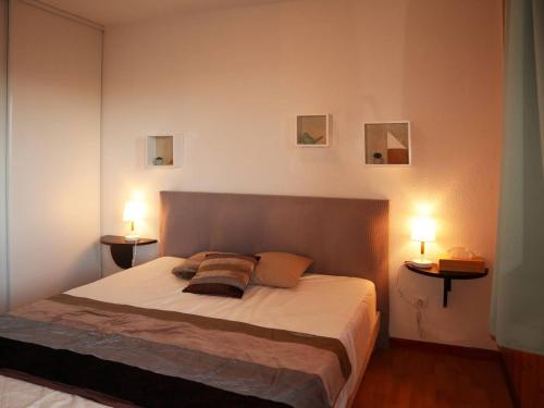 une chambre avec un grand lit avec deux lampes dans l'établissement Appartement au pied des pistes avec piscine, sauna et hammam, 4 pers - FR-1-322-33, aux Orres