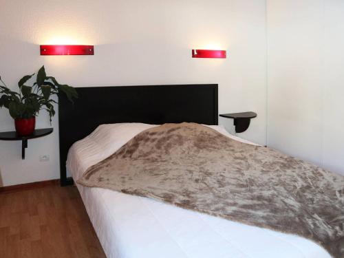 レ・ゾルにあるAppartement Les Orres, 2 pièces, 4 personnes - FR-1-322-47のベッドルーム1室(黒いヘッドボードと植物付)