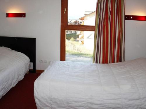 um quarto com uma cama branca e uma janela em Chalet Les Orres, 3 pièces, 6 personnes - FR-1-322-57 em Les Orres