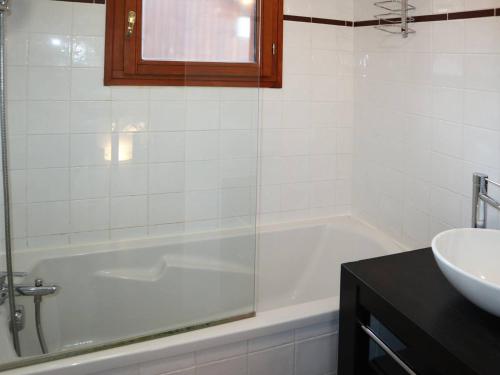 a white bathroom with a tub and a sink at Chalet Les Orres, 3 pièces, 6 personnes - FR-1-322-63 in Les Orres