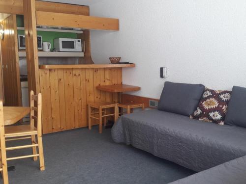Cette chambre comprend un lit, une table et un four micro-ondes. dans l'établissement Studio lumineux pour 5 pers, proche pistes et commerces, Arc 1800 - FR-1-411-341, à Arc 1800