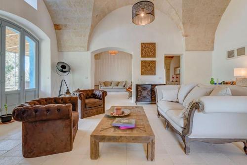 Una sala de estar con dos sofás y una mesa. en Masseria Tufo Bianco by Raro Villas, en Fasano