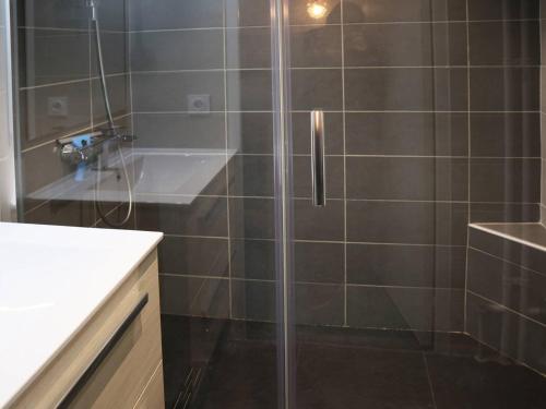une douche avec une porte vitrée dans une salle de bain dans l'établissement Studio pour 4 pers, au pied des pistes, vue sud, animaux admis - FR-1-322-55, aux Orres
