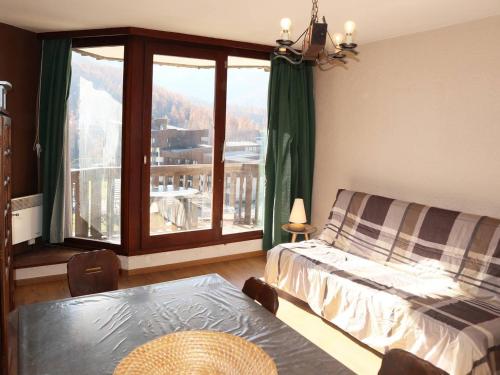une chambre avec un lit et une grande fenêtre dans l'établissement Grand studio skis aux pieds, 4 pers, Les Orres - FR-1-322-81, aux Orres