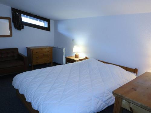 una camera da letto con un grande letto bianco e un tavolo di Appartement Les Orres, 4 pièces, 8 personnes - FR-1-322-106 a Les Orres