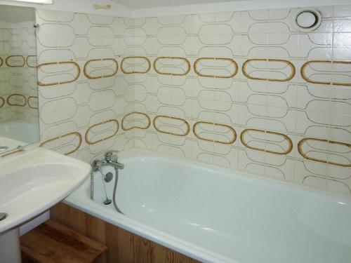 une salle de bain avec une baignoire blanche et un lavabo dans l'établissement Duplex 8 pers, exposé sud, terrasse, 6ème étage, proche pistes, bien équipé - FR-1-322-106, aux Orres