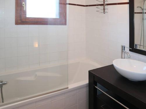 y baño blanco con lavabo, bañera y lavamanos. en Chalet Les Orres, 3 pièces, 6 personnes - FR-1-322-110 en Les Orres