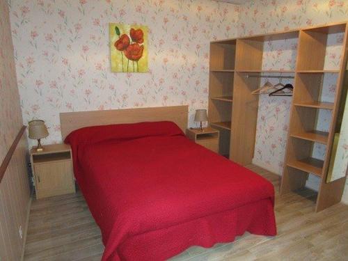 um pequeno quarto com uma cama vermelha e prateleiras em Appartement Cauterets, 3 pièces, 5 personnes - FR-1-234-138 em Cauterets